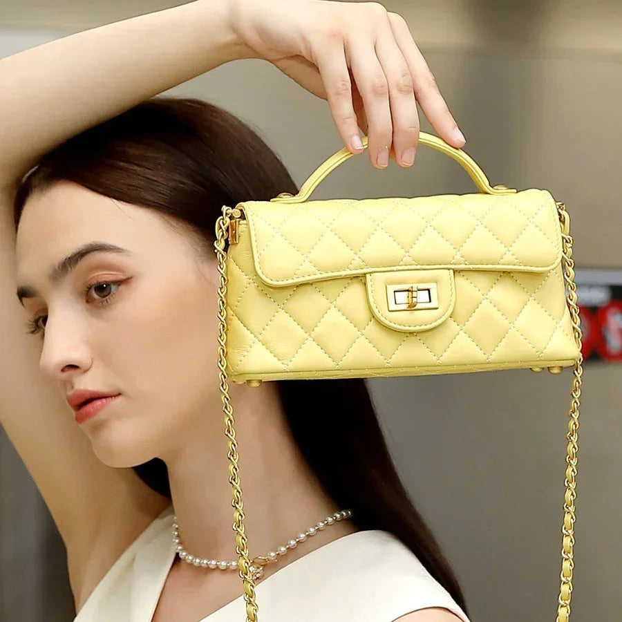Woman modeling a quilted yellow leather handbag with chain strap and turn-lock closure