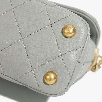 Gray quilted leather handbag corner with gold metal studs