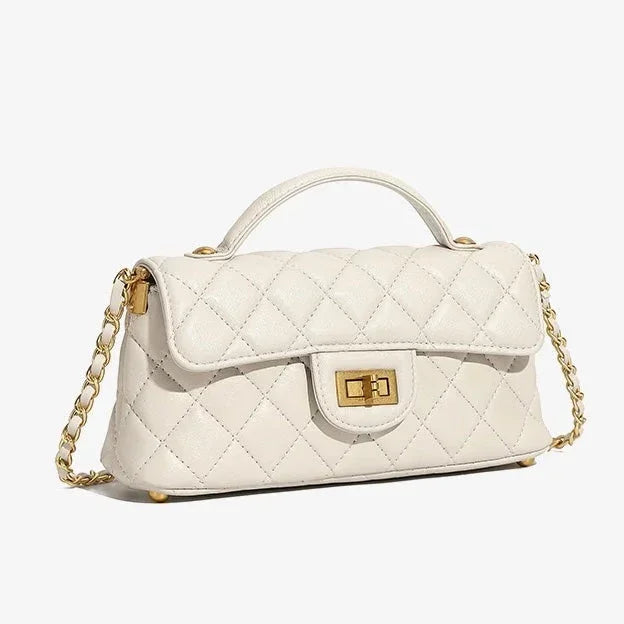 White quilted leather handbag with gold chain strap and top handle on white background