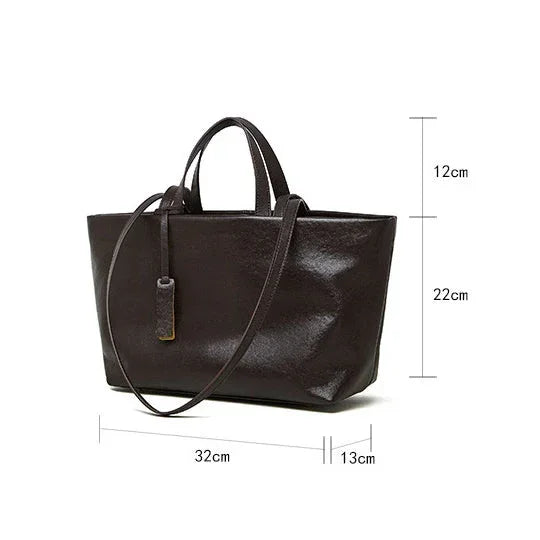 Black leather tote handbag with long strap and size dimensions 32x13x22 cm