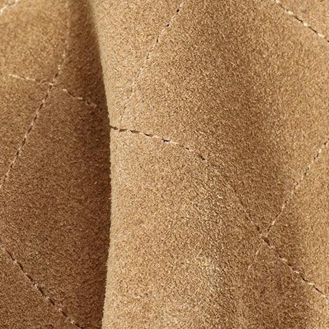 Close-up of tan suede quilted fabric with visible stitching detail