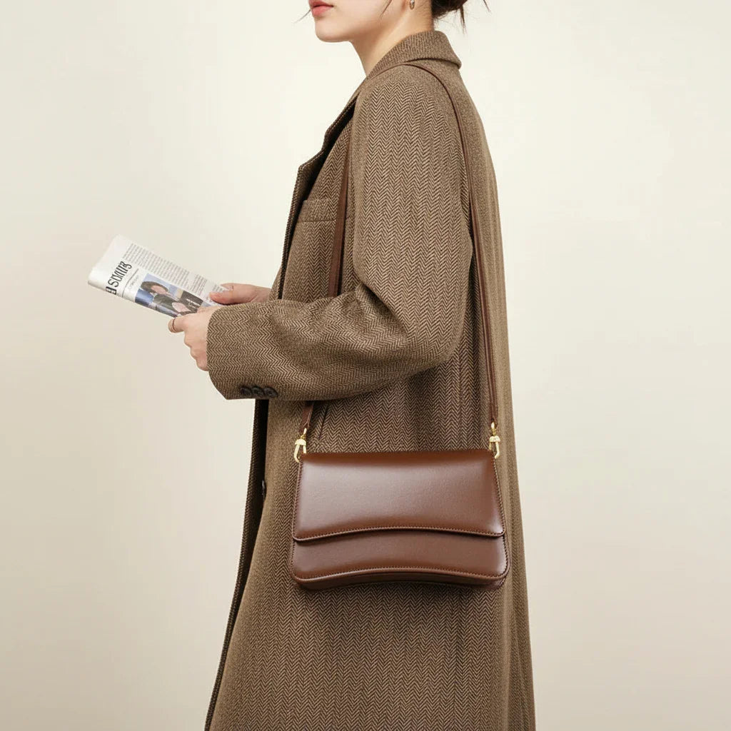 Woman wearing brown herringbone blazer with a brown leather shoulder bag