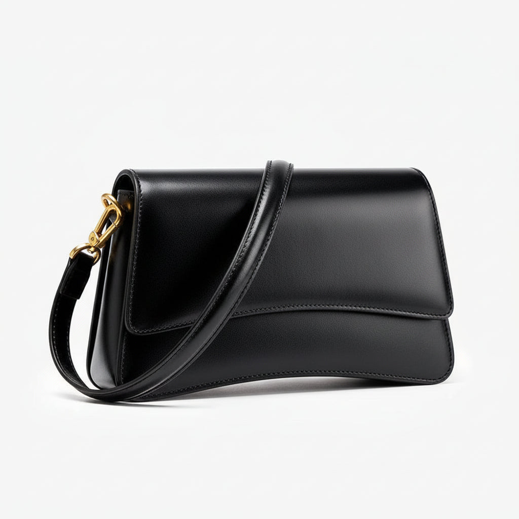Black leather shoulder bag with gold hardware on white background