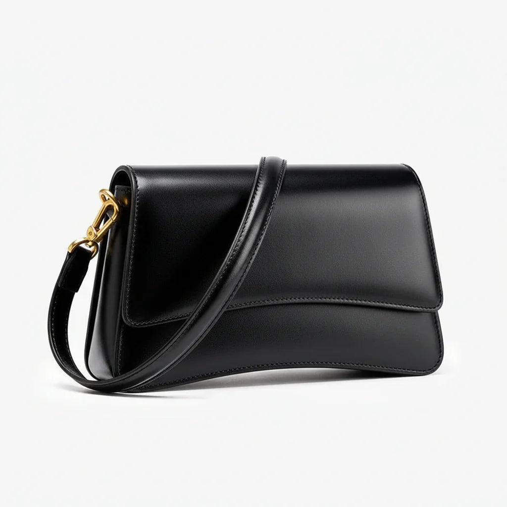 Black leather shoulder bag with gold hardware on white background