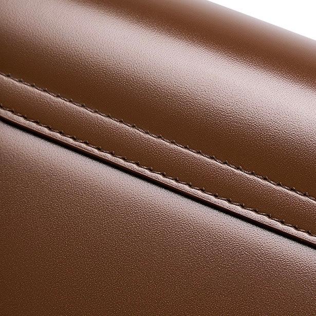 Close-up of brown leather with fine stitching, luxury bag material texture