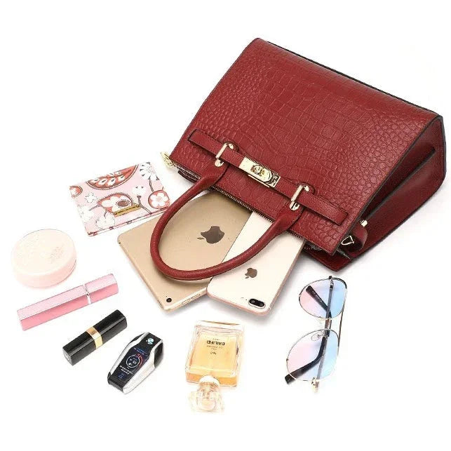 Red leather handbag with wallet, sunglasses, phone, cosmetics, perfume, and car key