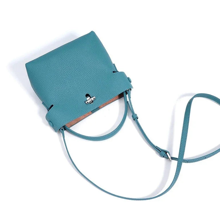 Blue leather crossbody bag with silver clasp and adjustable strap on white background
