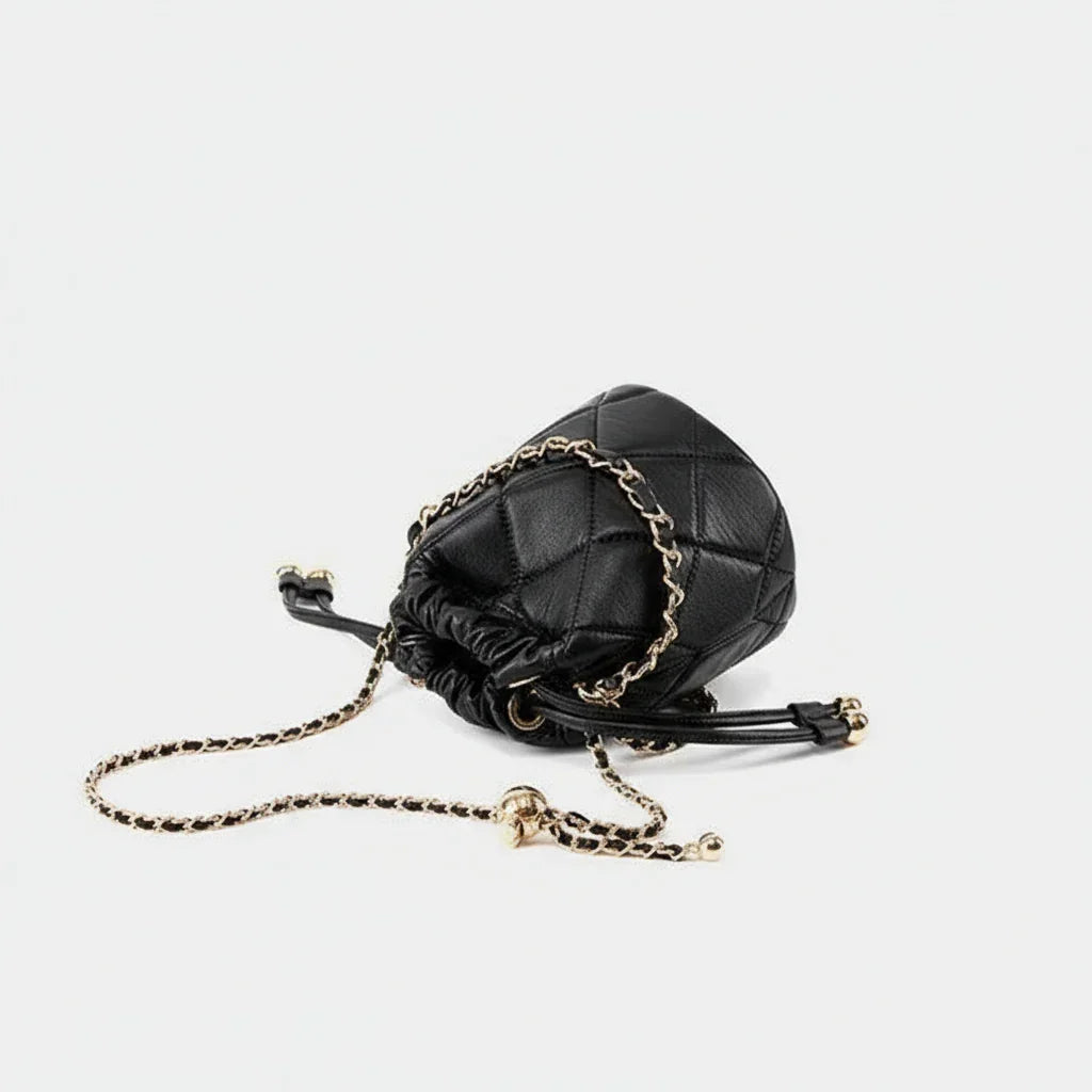 Black quilted leather bucket bag with gold chain strap on white background