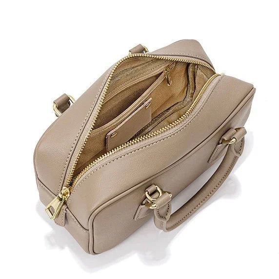 Beige leather handbag with gold zippers, top handle, and organized interior compartments