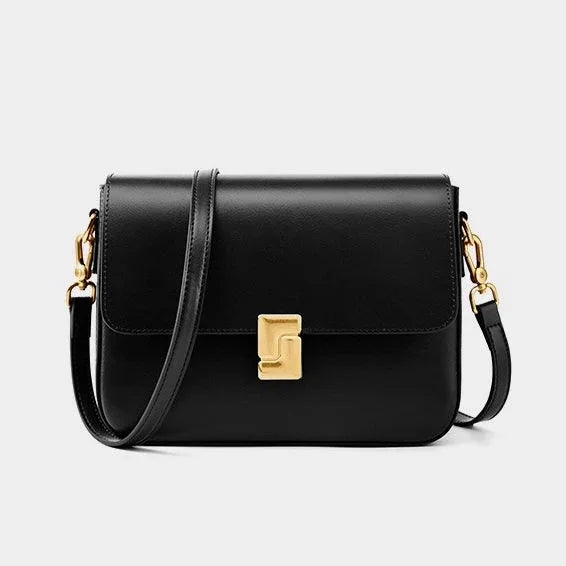 Black leather crossbody bag with gold clasp and hardware on a white background