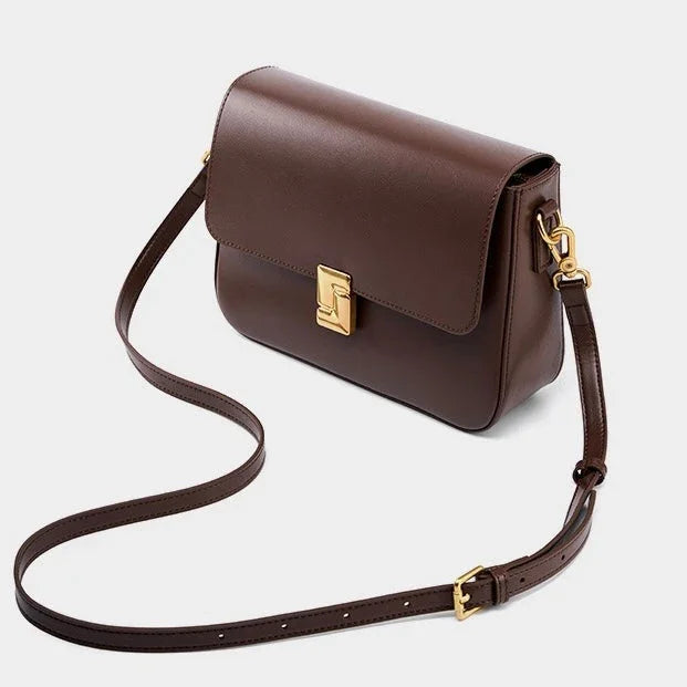 Brown leather crossbody bag with gold buckle on white background