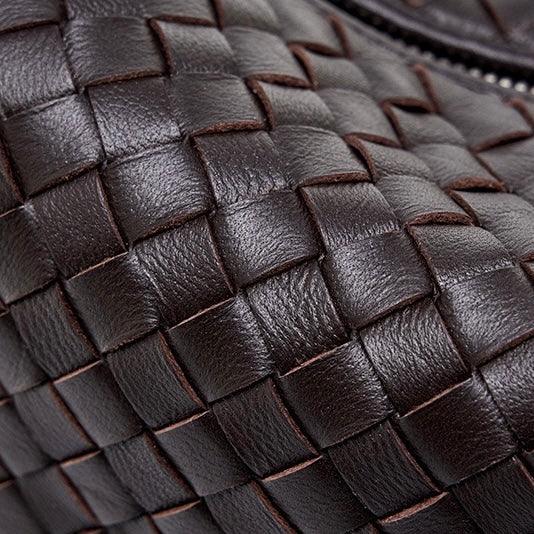 Close-up of dark brown woven leather handbag texture with visible zipper detail