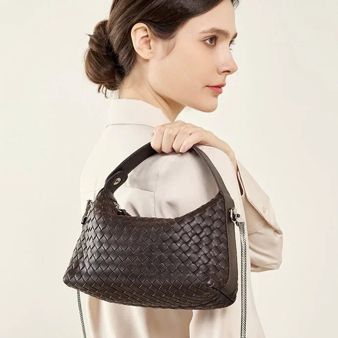 Woman in beige coat carrying a dark brown woven leather shoulder bag