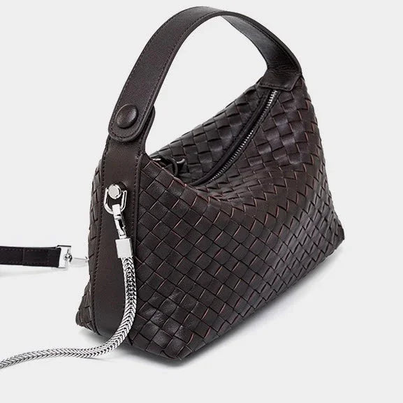 Dark brown woven leather handbag with top handle and silver chain strap on white background