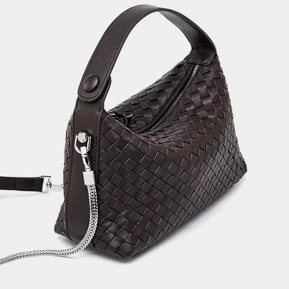 Dark brown woven leather handbag with top handle and silver chain strap on white background