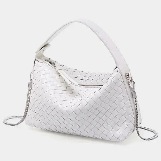 White woven leather handbag with zip closure and silver chain strap on a light background