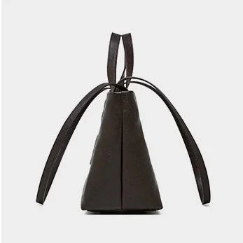 Side view of black leather bucket bag with top handles and drawstring straps