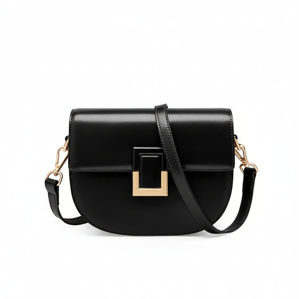 Black leather crossbody bag with gold buckle and adjustable strap on white background