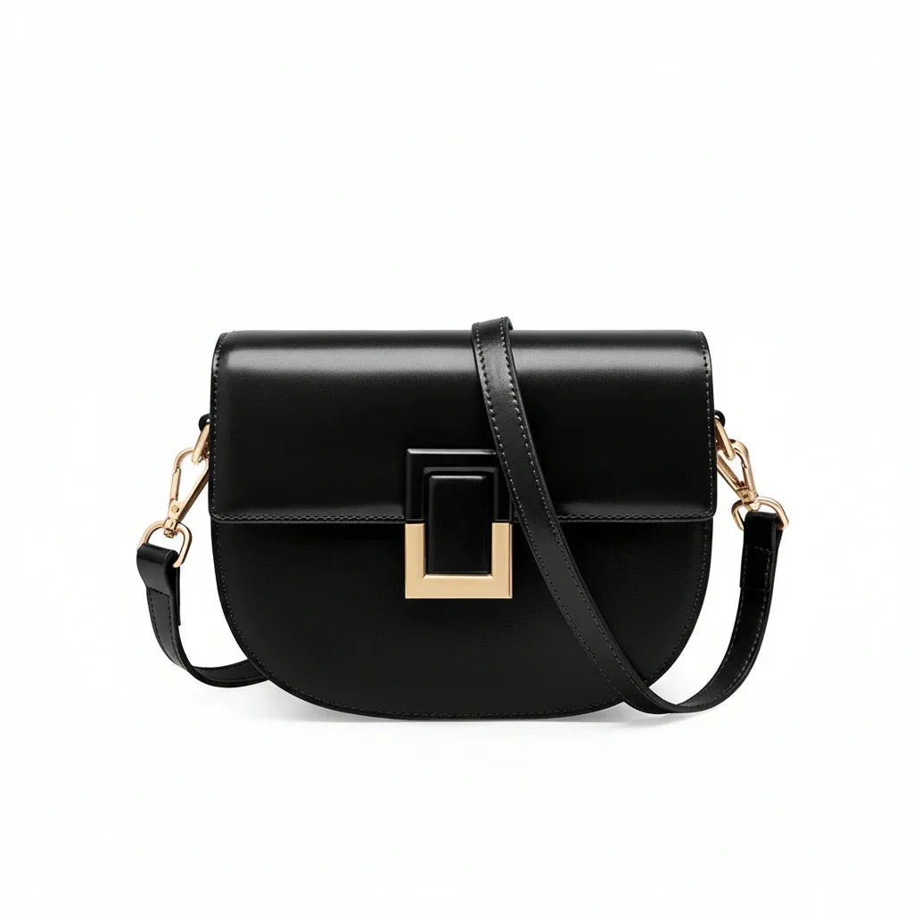 Black leather crossbody bag with gold buckle and adjustable strap on white background
