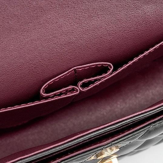Close-up of quilted leather purse interior with burgundy lining and stitched pocket
