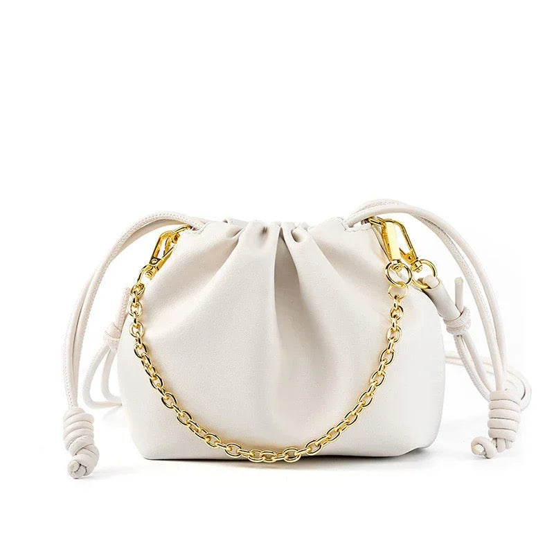 White drawstring pouch handbag with gold chain on white background