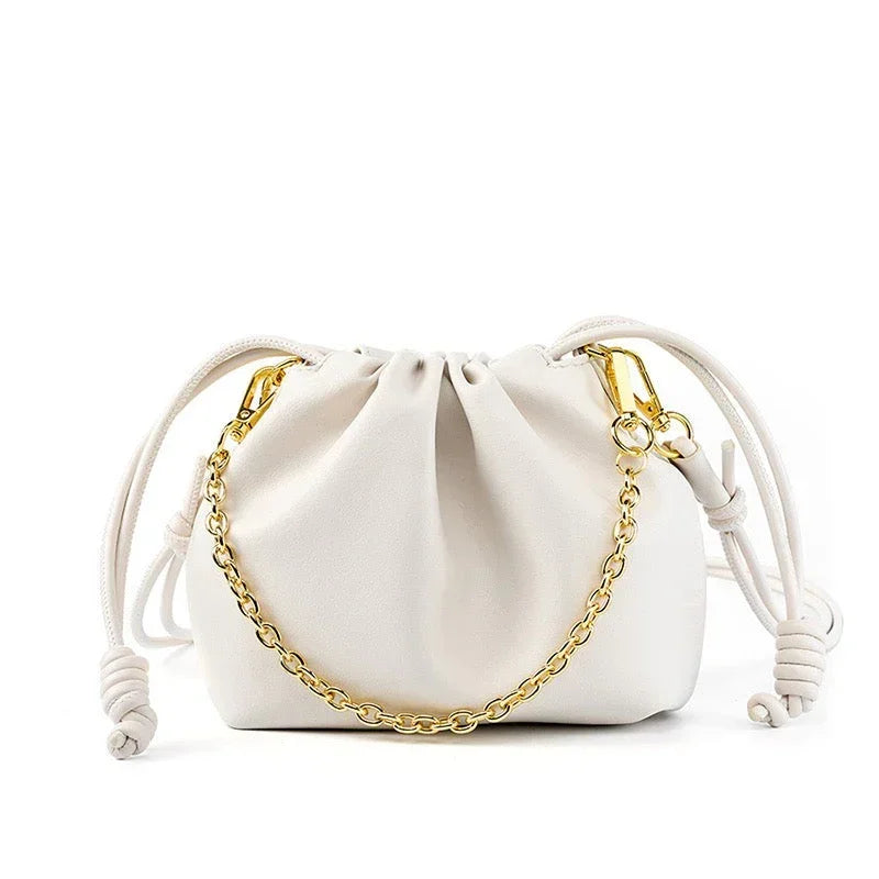 White drawstring pouch handbag with gold chain on white background