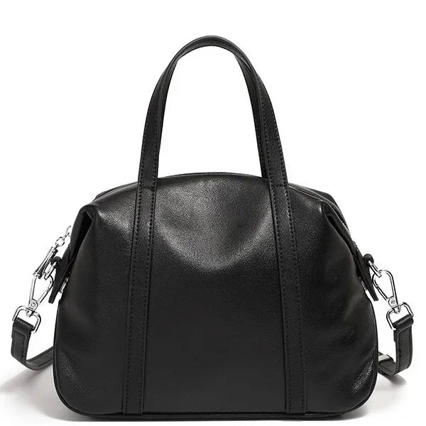 Black leather handbag with top handles and detachable shoulder strap on white background