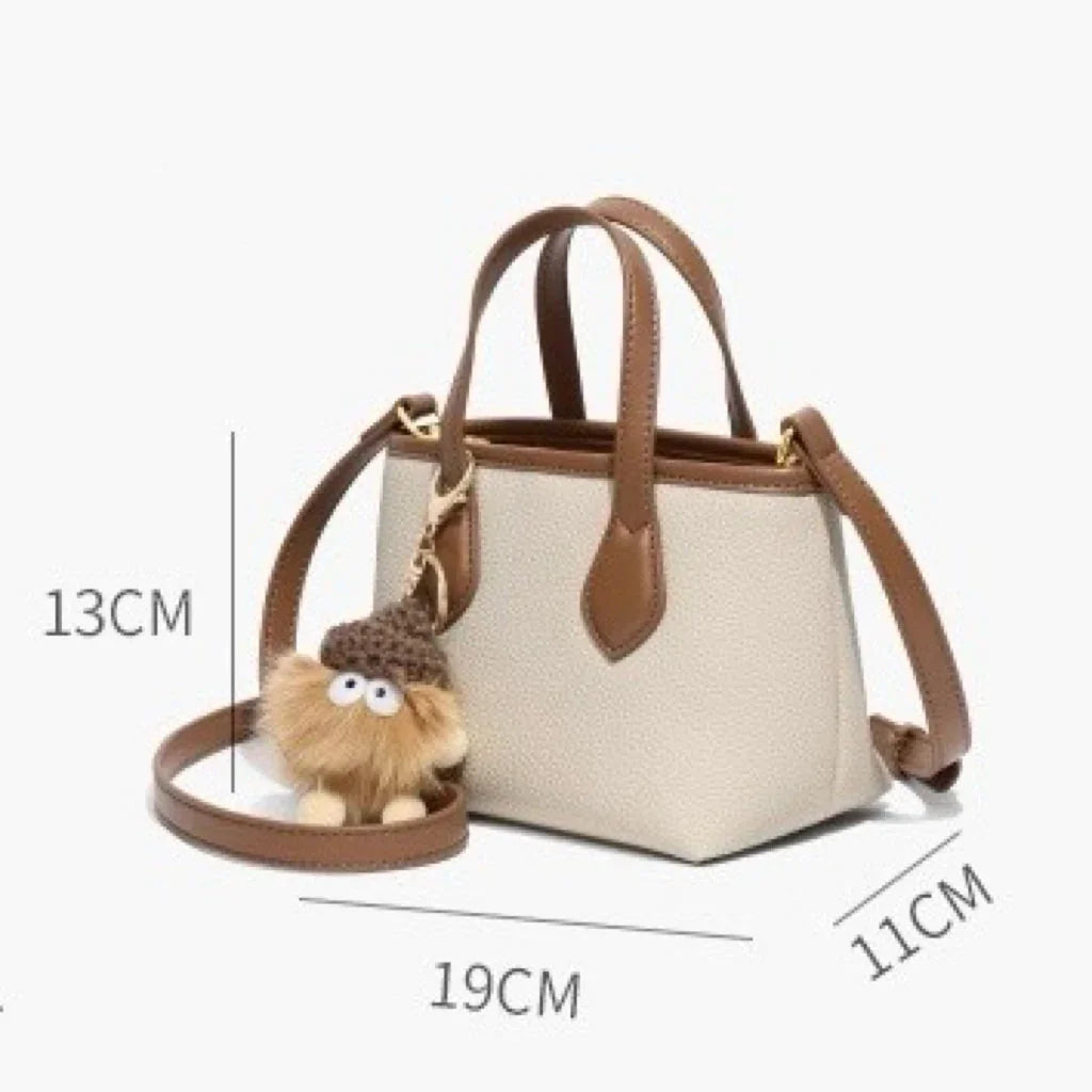 Small beige and brown handbag with shoulder strap, plush keychain, and size dimensions shown.