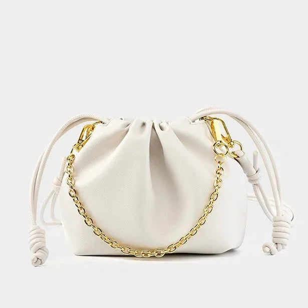 White leather drawstring bag with gold chain and knots, minimalist purse on white background