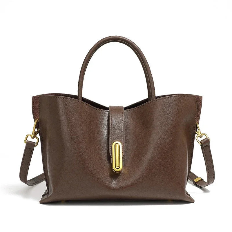 Brown leather tote bag with gold hardware and detachable shoulder strap on white background