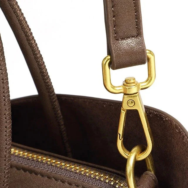 Brown leather handbag with gold zipper and gold clasp detail