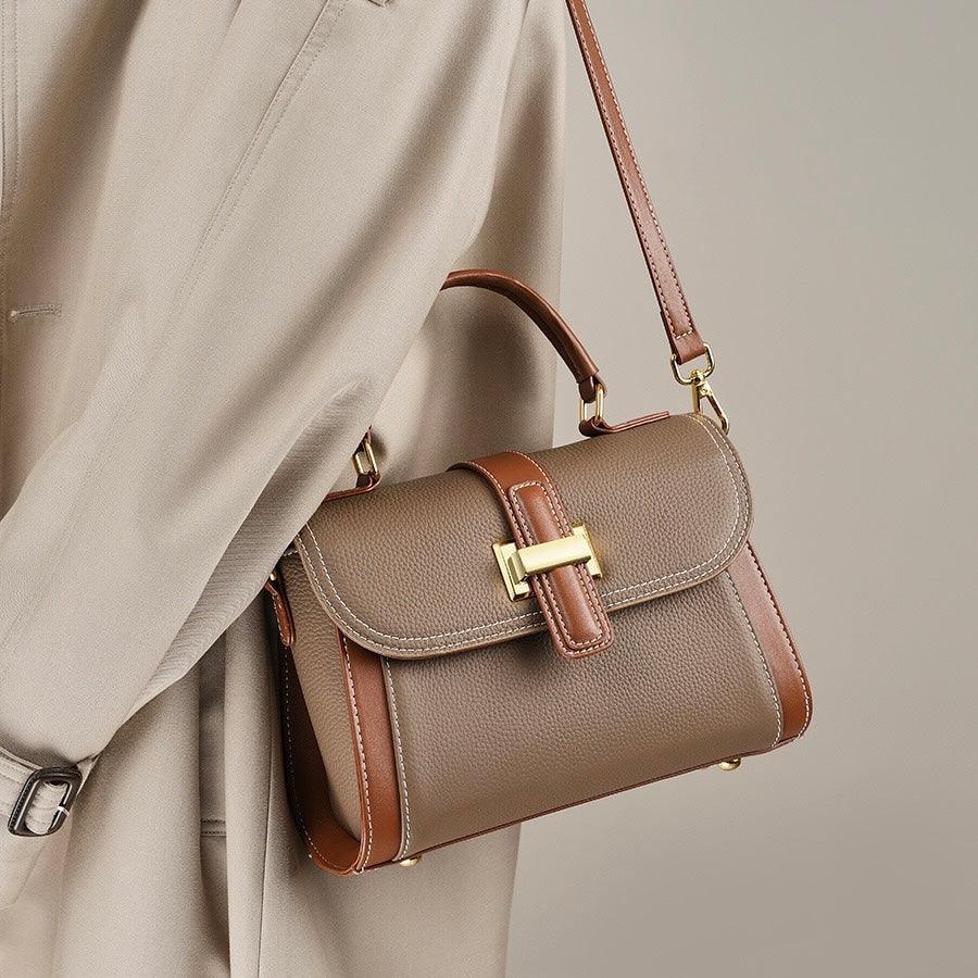 Brown leather shoulder bag with gold hardware on beige coat