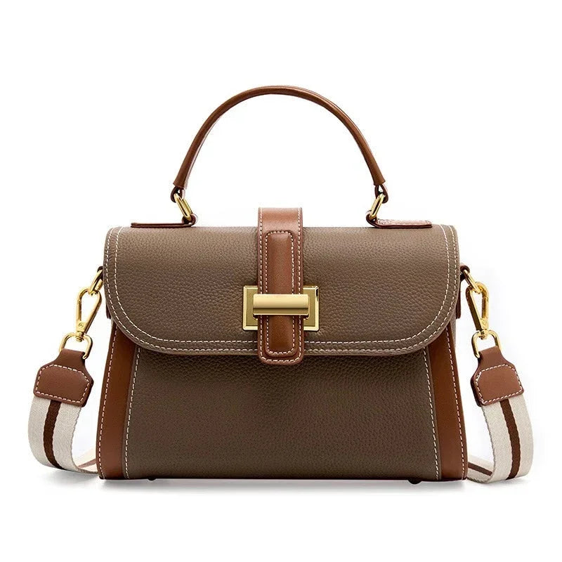 Brown leather handbag with top handle, gold hardware, and adjustable shoulder strap