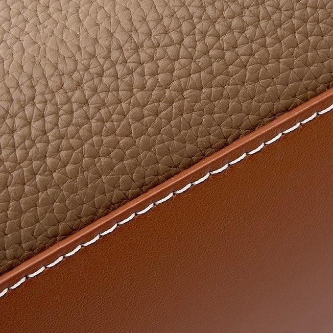 Brown textured leather with white stitching, close-up of luxury leather material