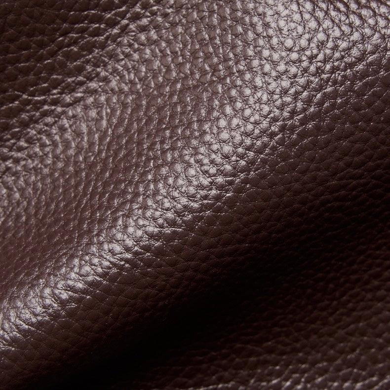 Close-up of textured dark brown leather material with visible grain pattern