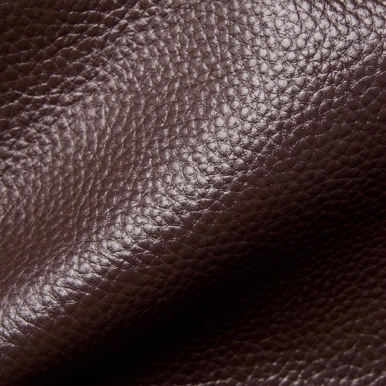Close-up of textured dark brown leather material with visible grain pattern