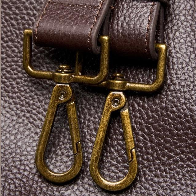 Close-up of brown leather bag with brass clasps and textured leather surface