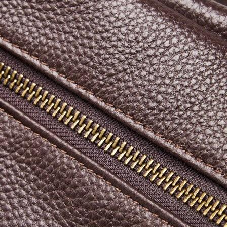 Close-up of brown textured leather with brass zipper, leather bag material detail
