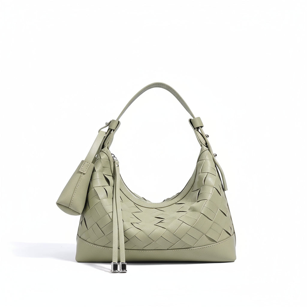 Sage green woven leather shoulder bag with top handle and zip pouch on white background