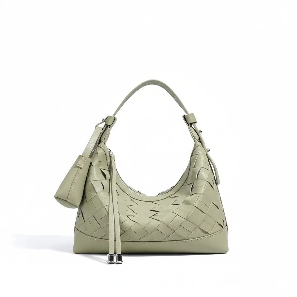 Sage green woven leather shoulder bag with top handle and zip pouch on white background