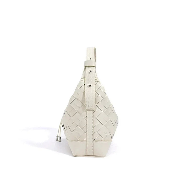 White woven leather sling bag with buckle and drawstring on white background