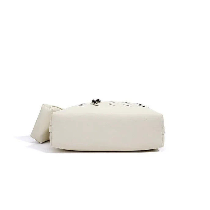 Bottom view of a white square leather handbag with geometric stitching on a white background