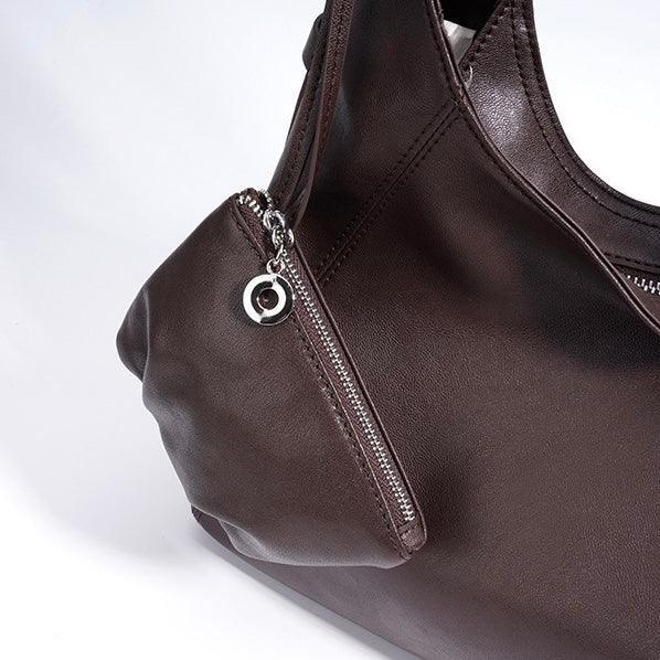 Dark brown leather handbag with zipper pocket and silver charm detail