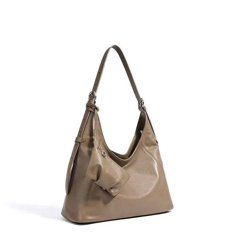Taupe leather shoulder bag with bow detail on white background