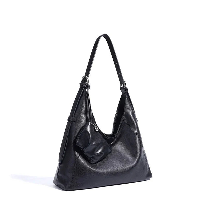 Black leather shoulder bag with attached coin purse on white background