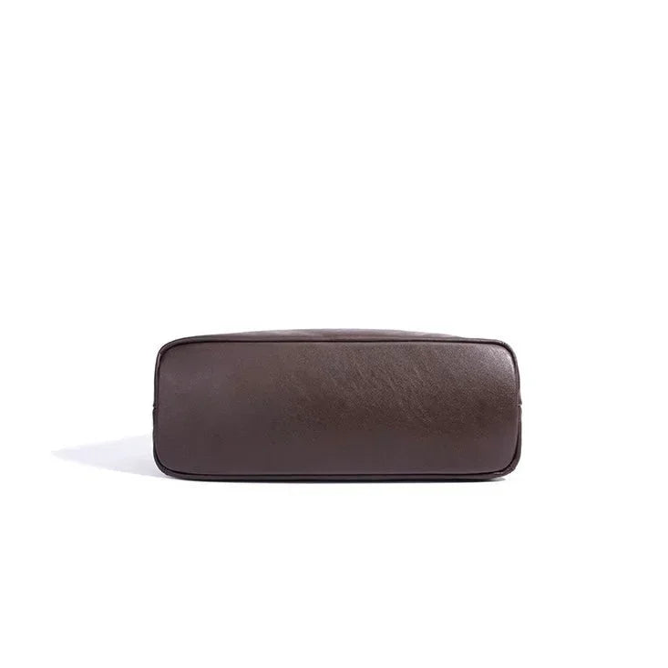 Bottom view of a brown leather bag on a white background