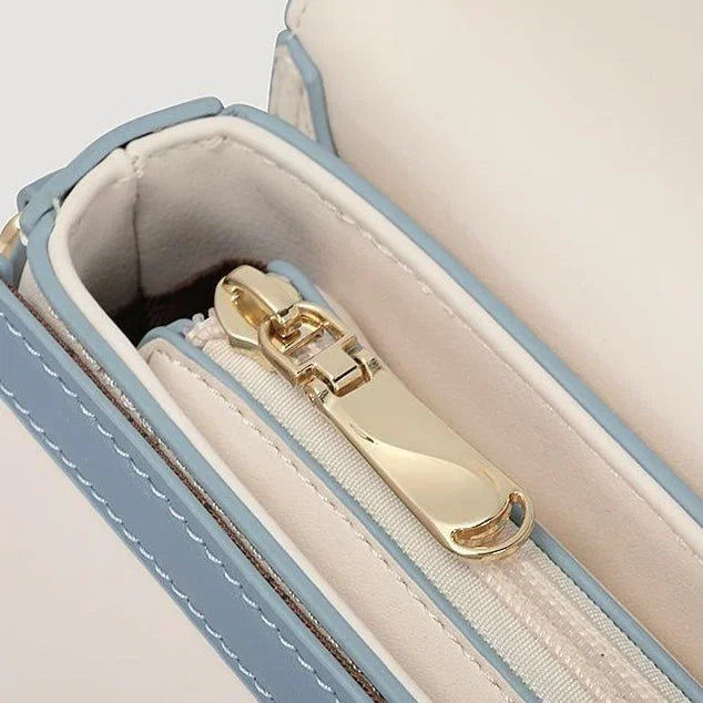 Close-up of blue and white purse interior with gold zipper detail
