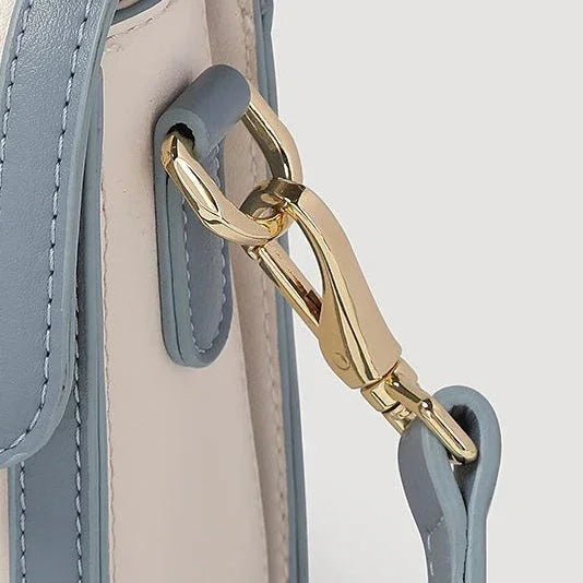 Light blue leather handbag with gold clasp and strap detail close-up