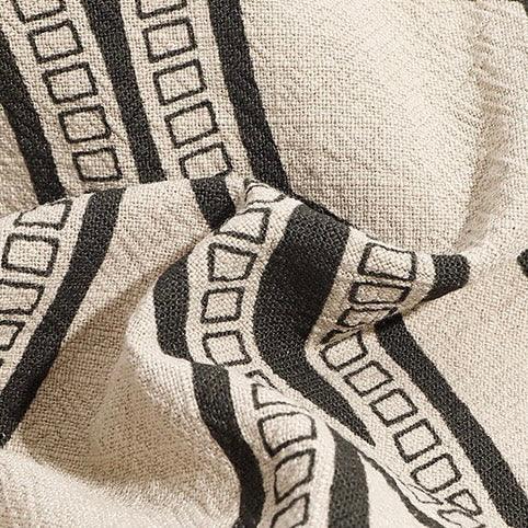 Beige textured fabric with black geometric striped square pattern, modern textile design