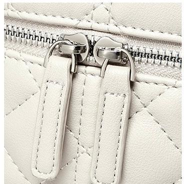 Close-up of white quilted leather bag with double zipper pull and silver hardware
